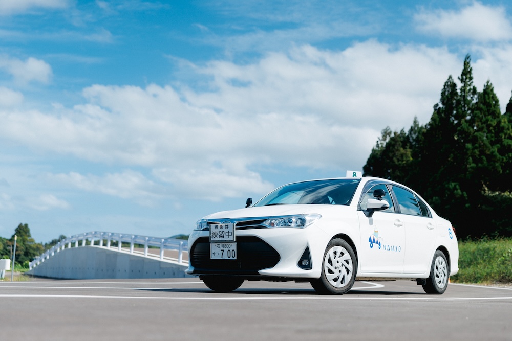 教習コースでの写真。教習車と、練習用の坂道が写っています。